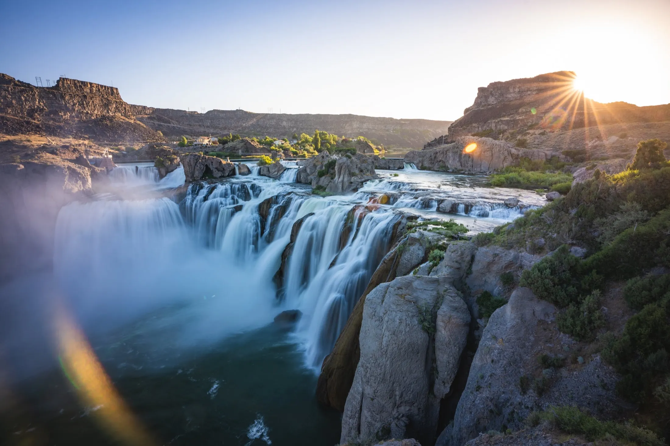 Shoshone Falls on the Snake River at sunset, with mist rising over the canyon
